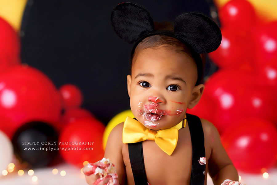 cake smash photographer near Carrollton, GA; baby in bowtie with cake on face