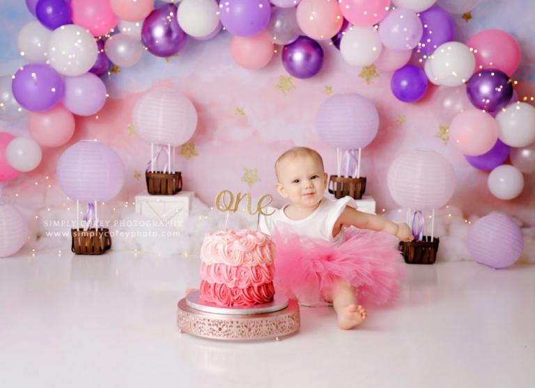 cake smash photographer near Carrollton, GA; baby girl with pastel hot air balloons