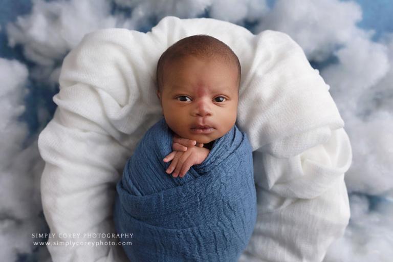 newborn photographer near Carrollton, GA; baby boy in blue with clouds