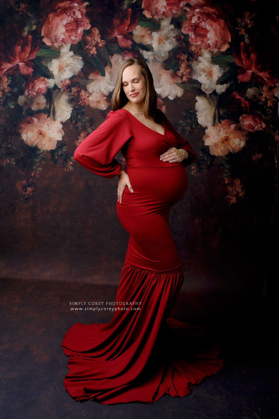 Atlanta maternity photographer-mom in red dress with floral studio backdrop