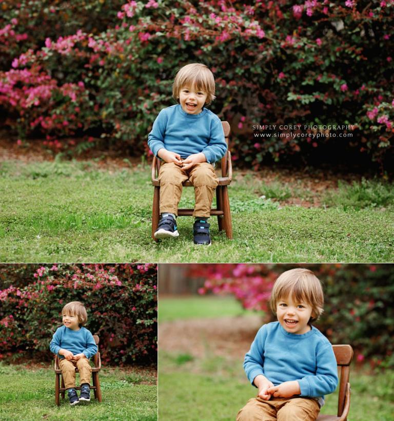 Bremen child photographer, boy outside in chair by spring blossoms