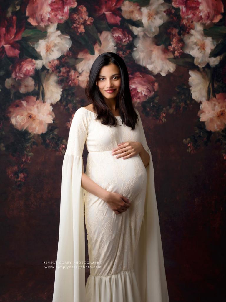 Carrollton maternity photographer, pregnant mom in white dress with floral backdrop