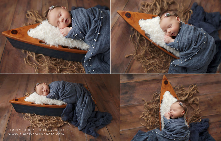 newborn photographer near Senoia, baby girl in navy wrap with wooden boat