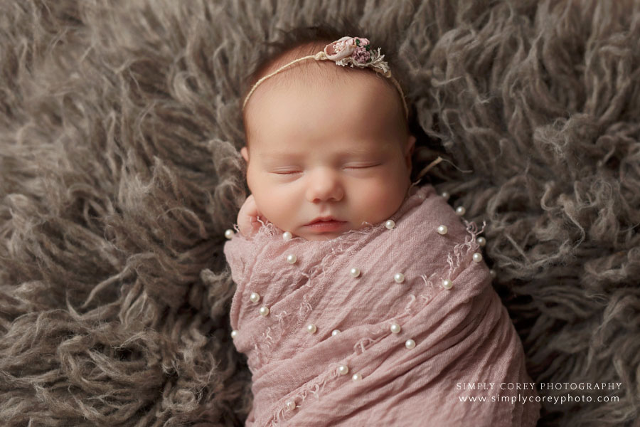 newborn photographer near Carrollton, GA; baby girl in pink pearl wrap