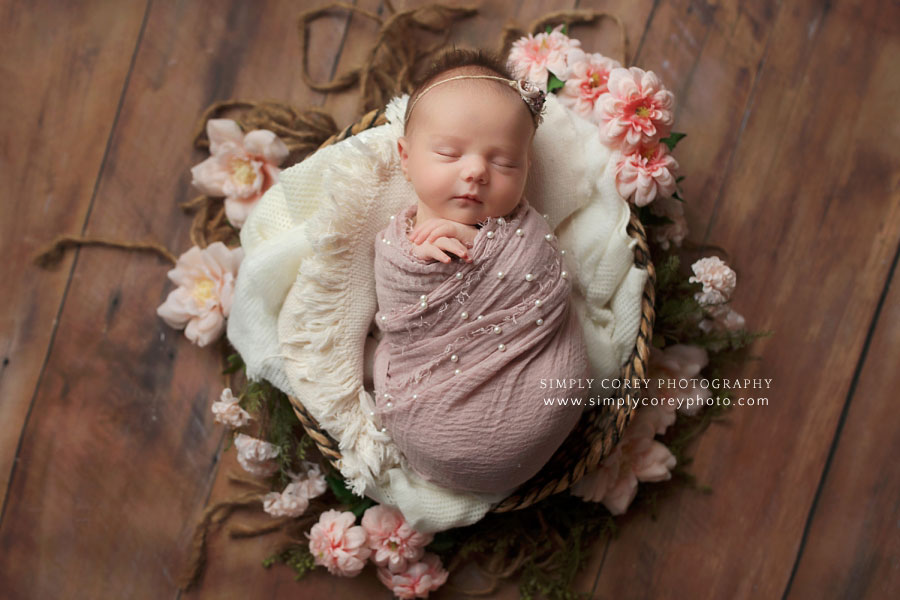 Villa Rica newborn photographer, baby girl in pink pearl swaddle in basket with flowers