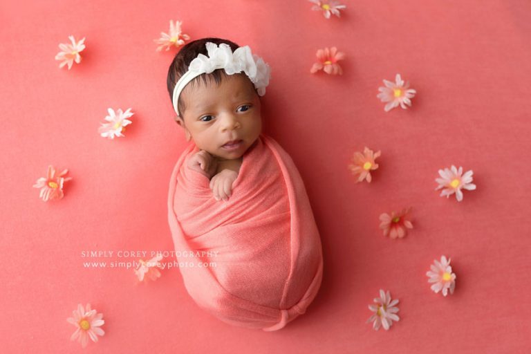 Atlanta newborn photographer, baby girl on coral studio backdrop with flowers