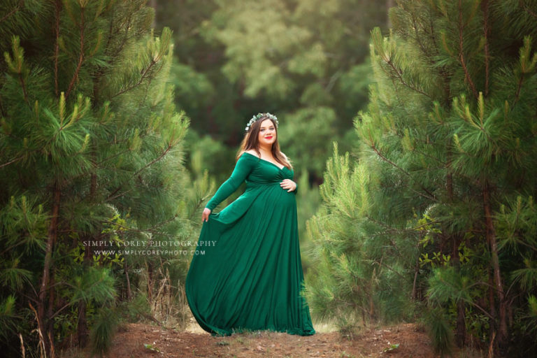 Atlanta maternity photographer, mom in green dress outside with pine trees