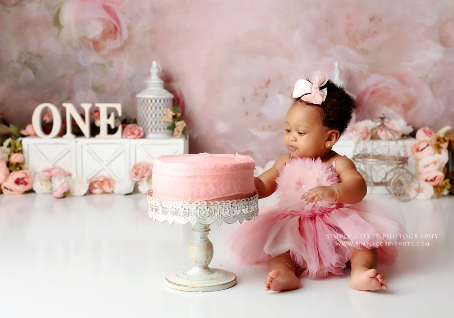 Newnan cake smash photographer, baby girl in tulle dress eating pink cake