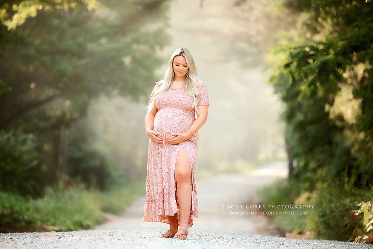maternity photographer near Newnan, pregnant mom in pink dress outside on dirt road