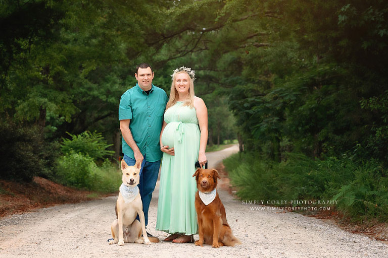 Newnan maternity photographer, expecting couple outside with two dogs