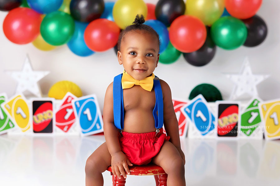 Newnan baby photographer, boy smiling in suspenders for uno milestone session