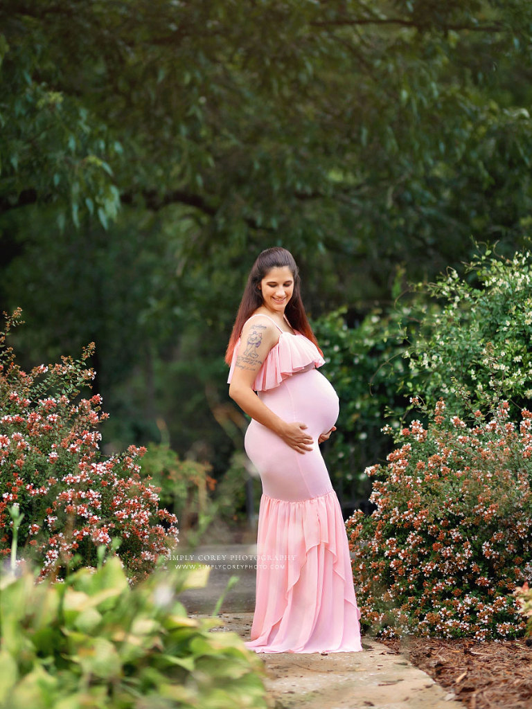 maternity photographer near Carrollton, GA; mom in pink dress outside with flowers