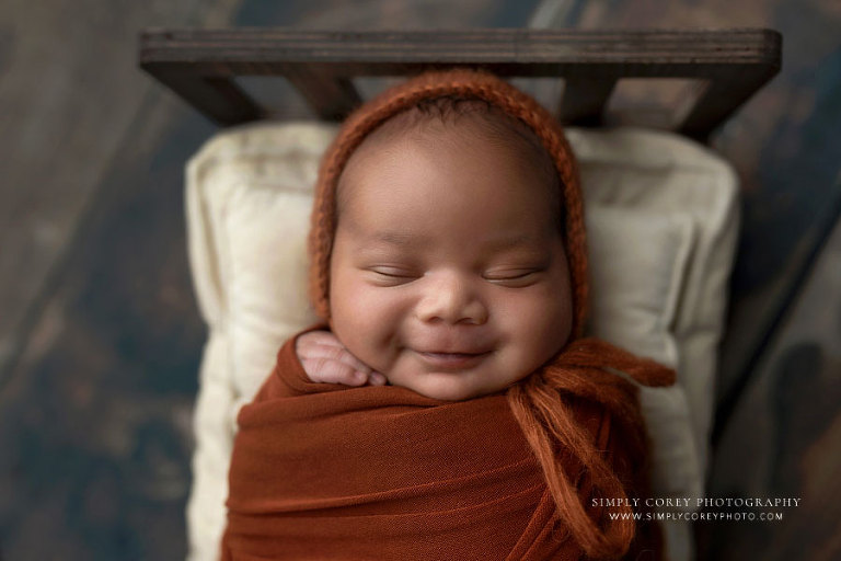 Atlanta newborn photographer, smiling baby boy in burnt orange set