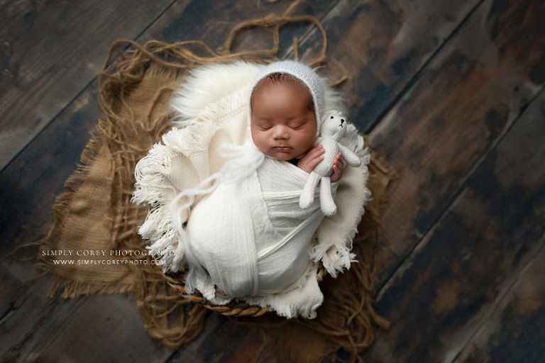 newborn photographer near Carrollton, GA; baby boy in white studio set with teddy bear