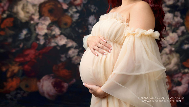 Bremen maternity photographer, studio pregnancy portrait with floral backdrop and tulle dress
