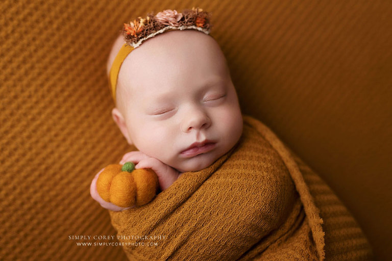 Atlanta newborn photographer, baby girl in mustard wrap with little pumpkin