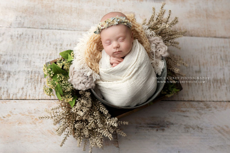 newborn photographer near Bremen, baby girl in bucket with light studio set