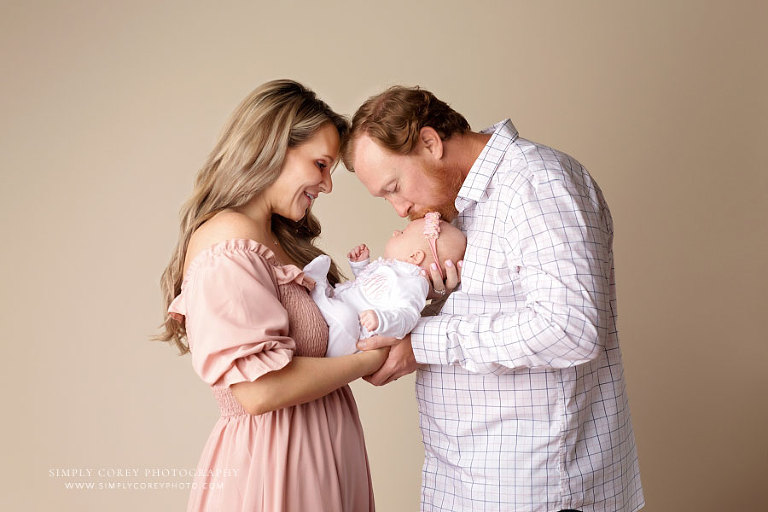 Newnan family photographer, parents holding newborn baby girl