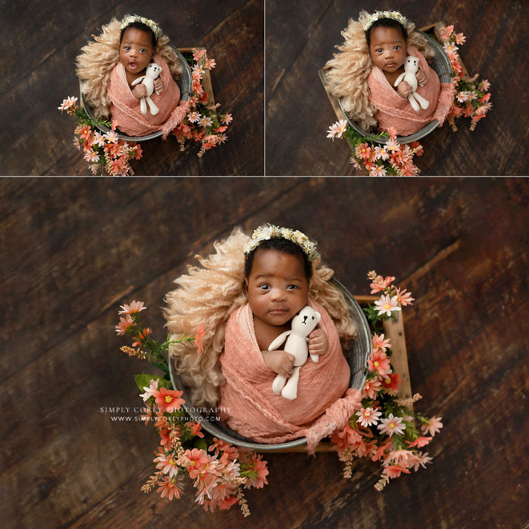 Douglasville newborn photographer, baby girl making funny expressions in bucket with flowers