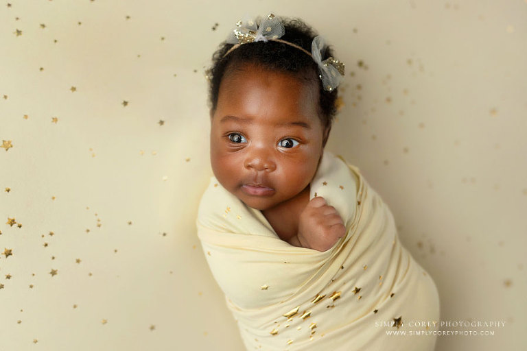 Villa Rica newborn photographer, awake baby girl with star wrap and studio backdrop