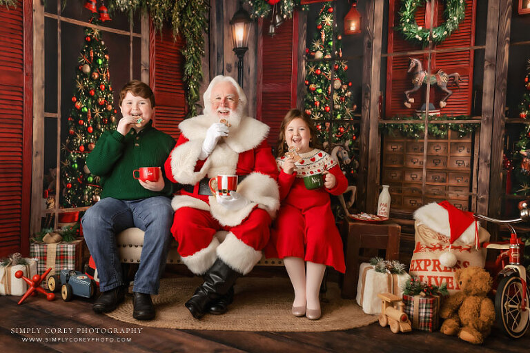 Christmas mini session photographer near Dallas, GA; kids having cookies with Santa Claus