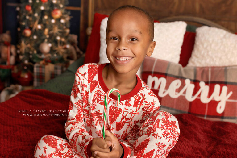 Atlanta mini session photographer, child in Christmas pajamas with candy cane