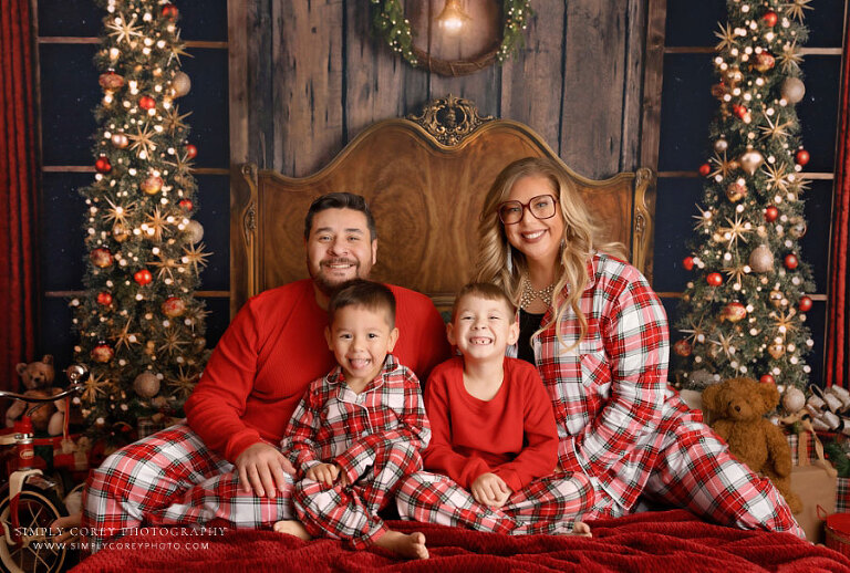 mini session photographer near Carrollton, GA; family in matching Christmas pajamas on a bed