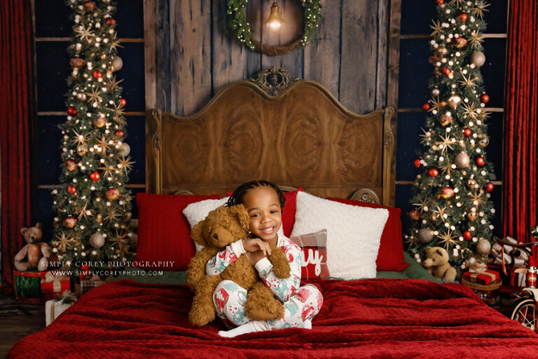 mini session photographer near Newnan, child in Christmas pajamas hugging teddy bear