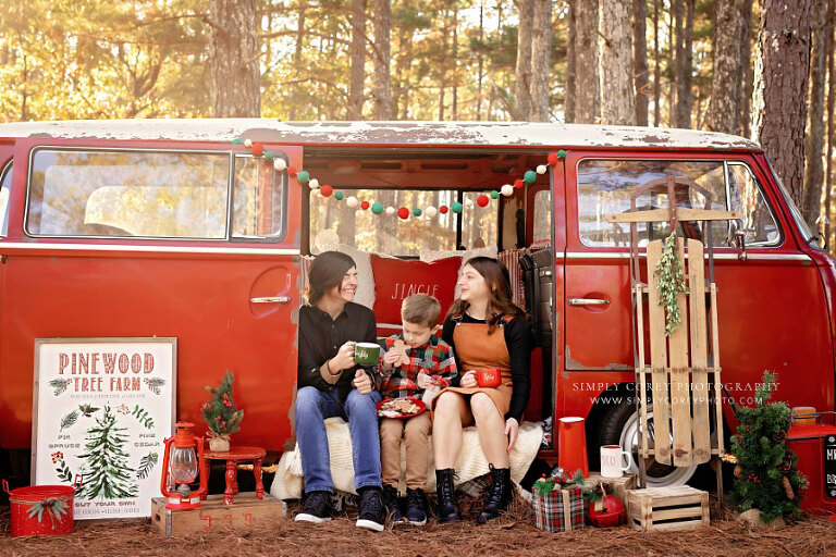 mini session photographer near Hiram, siblings laughing on outdoor VW Bus set for Christmas