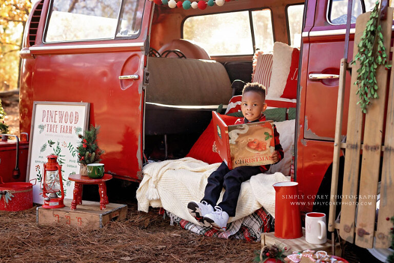mini session photographer near Douglasville, child outside with Christmas book in VW bus