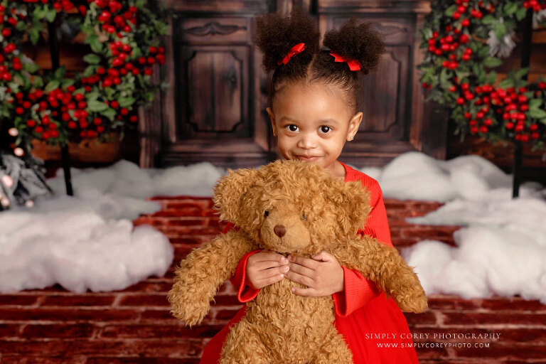 Carrollton baby photographer in Georgia, girl hugging bear during Christmas mini session