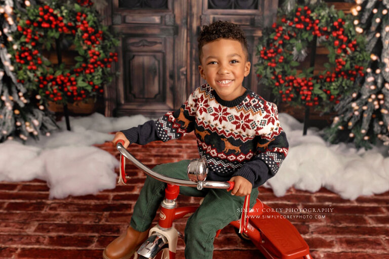 mini session photographer near Atlanta, child on tricycle on Christmas studio set