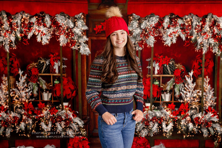 mini session photographer near Peachtree City, teen in knit hat on poinsettia Christmas studio set