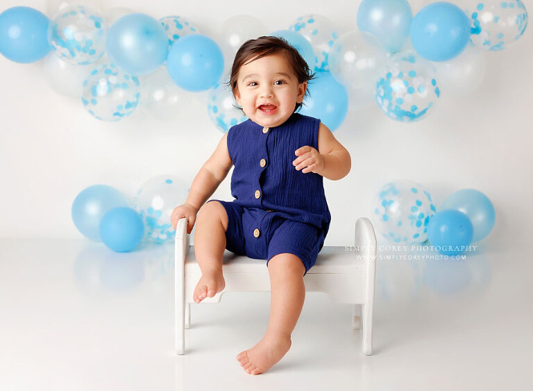 Douglasville baby photographer, boy with white and blue balloon garland in studio 