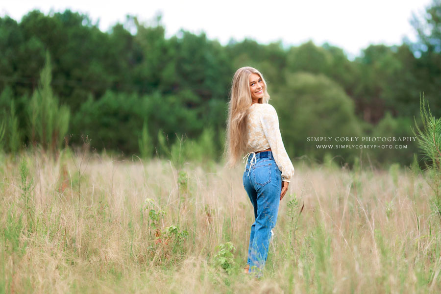 Atlanta senior portrait photographer, teen girl in jeans outside in field
