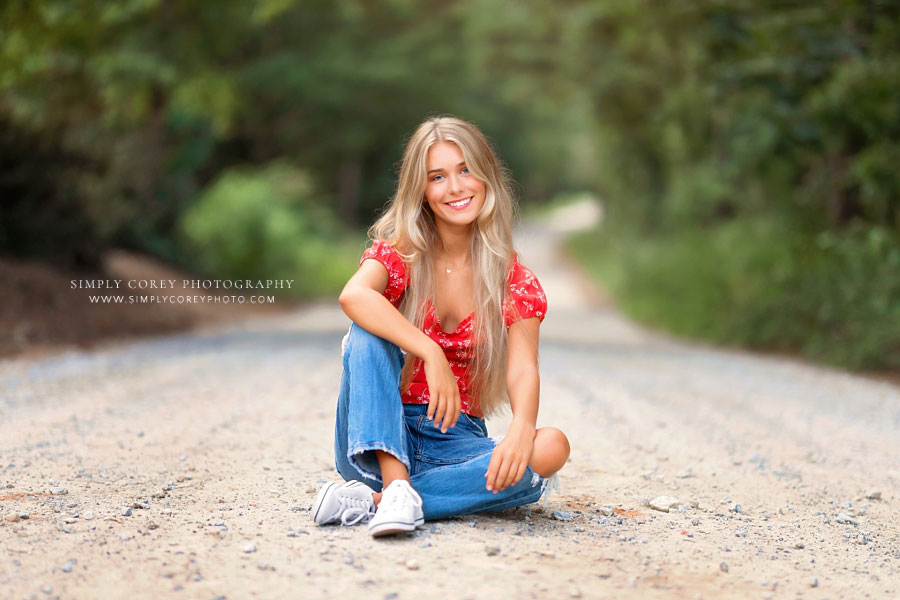 senior portrait photographer near Atlanta, teen girl outside sitting on dirt road