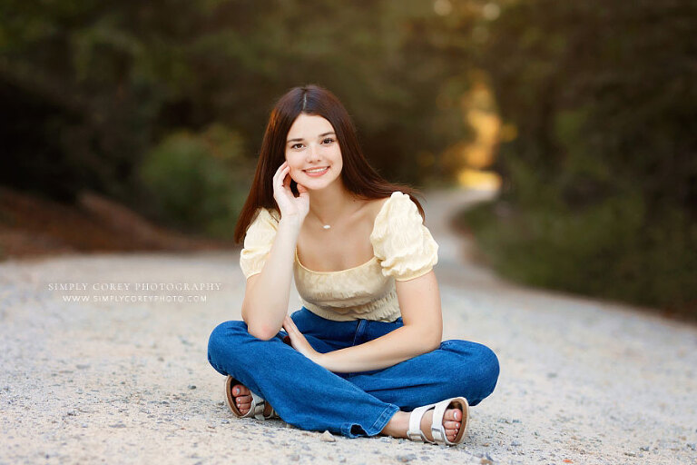 senior portrait photographer near Tyrone, teen girl sitting on dirt road
