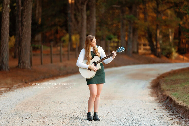 Newnan senior portrait photographer, teen girl in green outside on dirt road with guitar