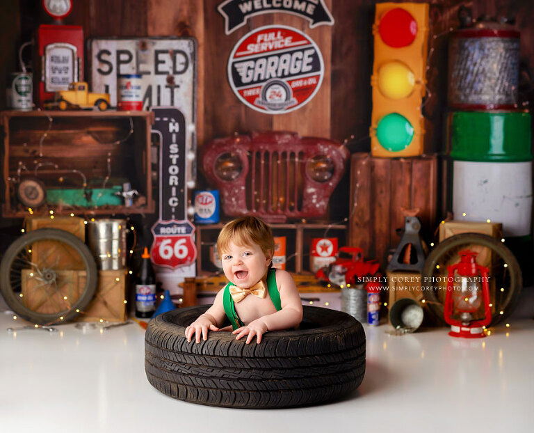 baby photographer near Atlanta, boy in tire on garage milestone set