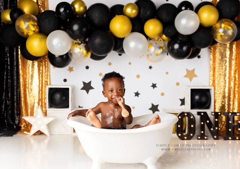 baby photographer near Carrollton, GA; boy in tub with feet up after cake smash