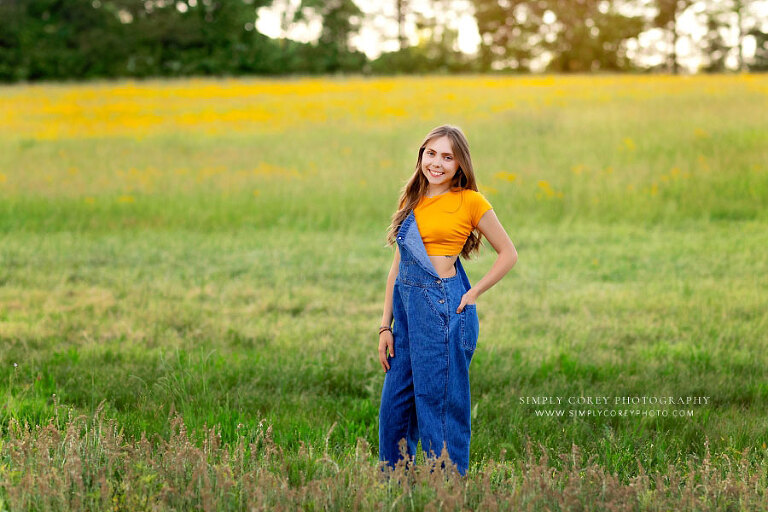 Dallas senior portrait photographer in GA, teen girl outside in field with overalls