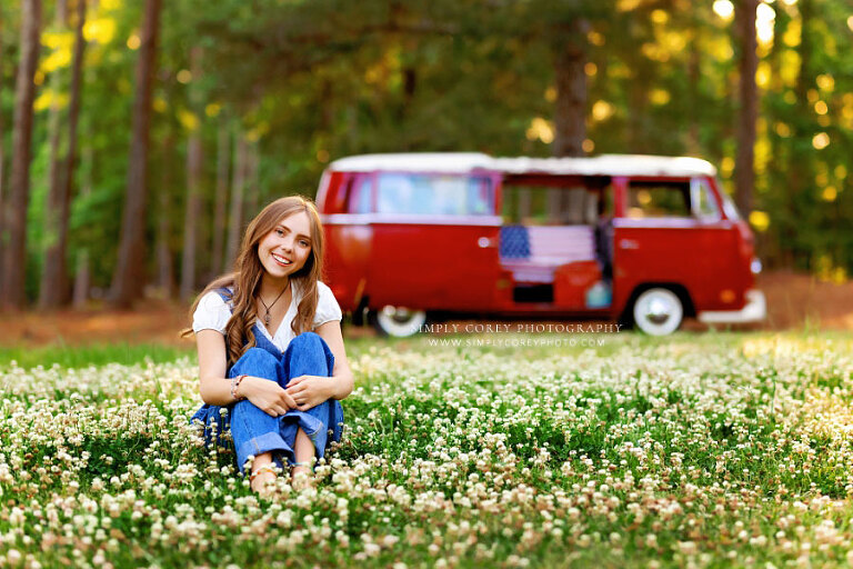 senior portrait photographer near Villa Rica, teen girl in grass with flowers and VW Bus
