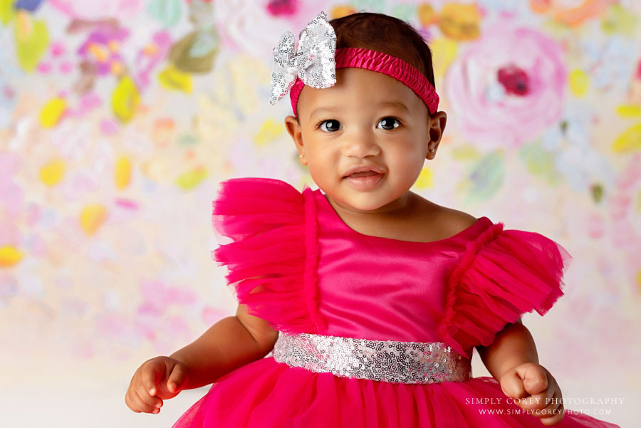 baby photographer near Lithia Springs, girl in pink dress with floral backdrop