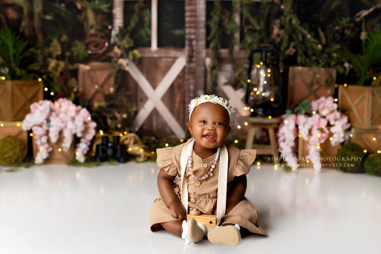 Atlanta baby photographer, girl smiling with toy camera on explorer studio set