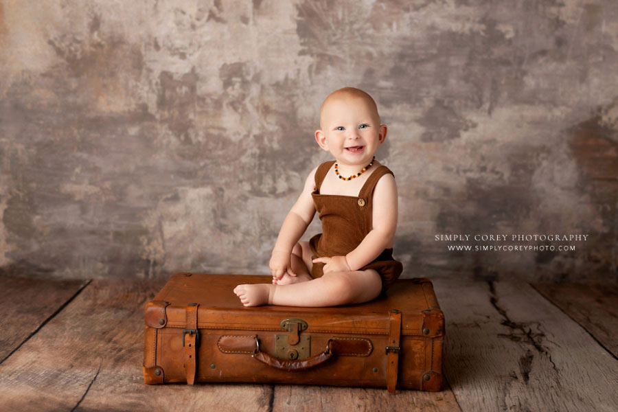 baby photographer near Carrollton, GA; boy sitting on vintage suitcase