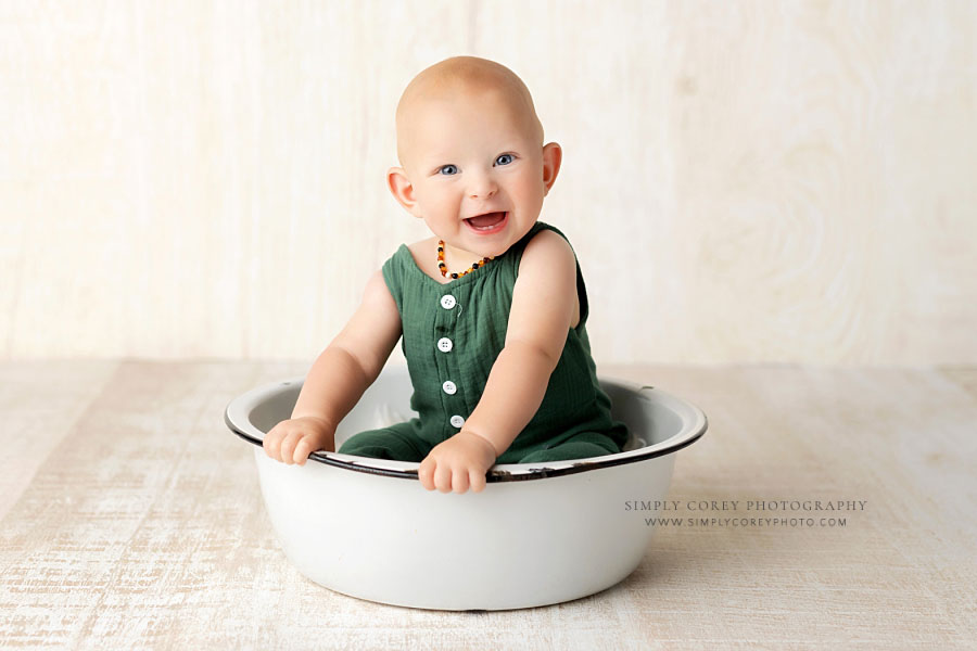 baby photographer near Dallas, GA; boy in green sitting in white basin in studio