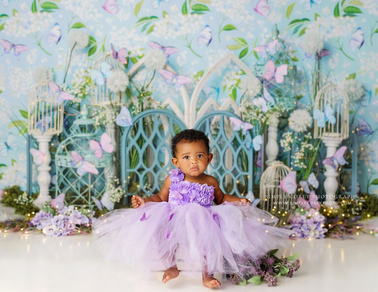 Carrollton baby photographer in Georgia, girl in butterfly dress on blue and purple studio set