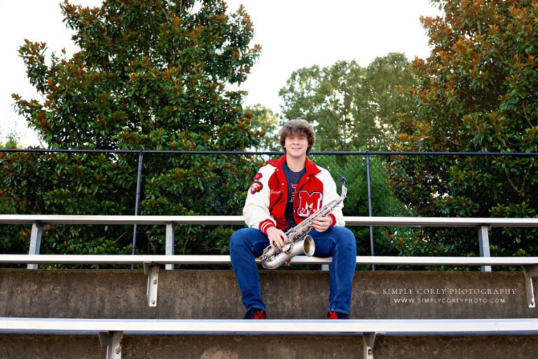 Douglasville senior portrait photographer, teen with saxophone and letterman jacket at Milton High