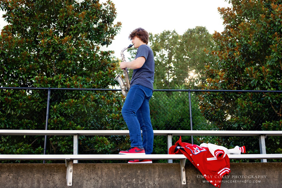 senior portrait photographer near Dallas, GA; teen playing saxophone on bleachers