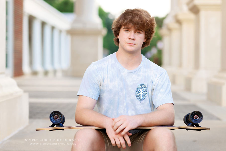 senior portrait photographer near Hiram, teen holding longboard skateboard